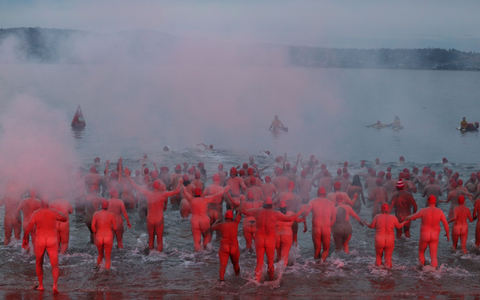 Menschen nehmen am jährlichen Nacktschwimmen zur Wintersonnenwende im tasmanischen Hobart teil. - Foto: Ethan James/AAP/dpa