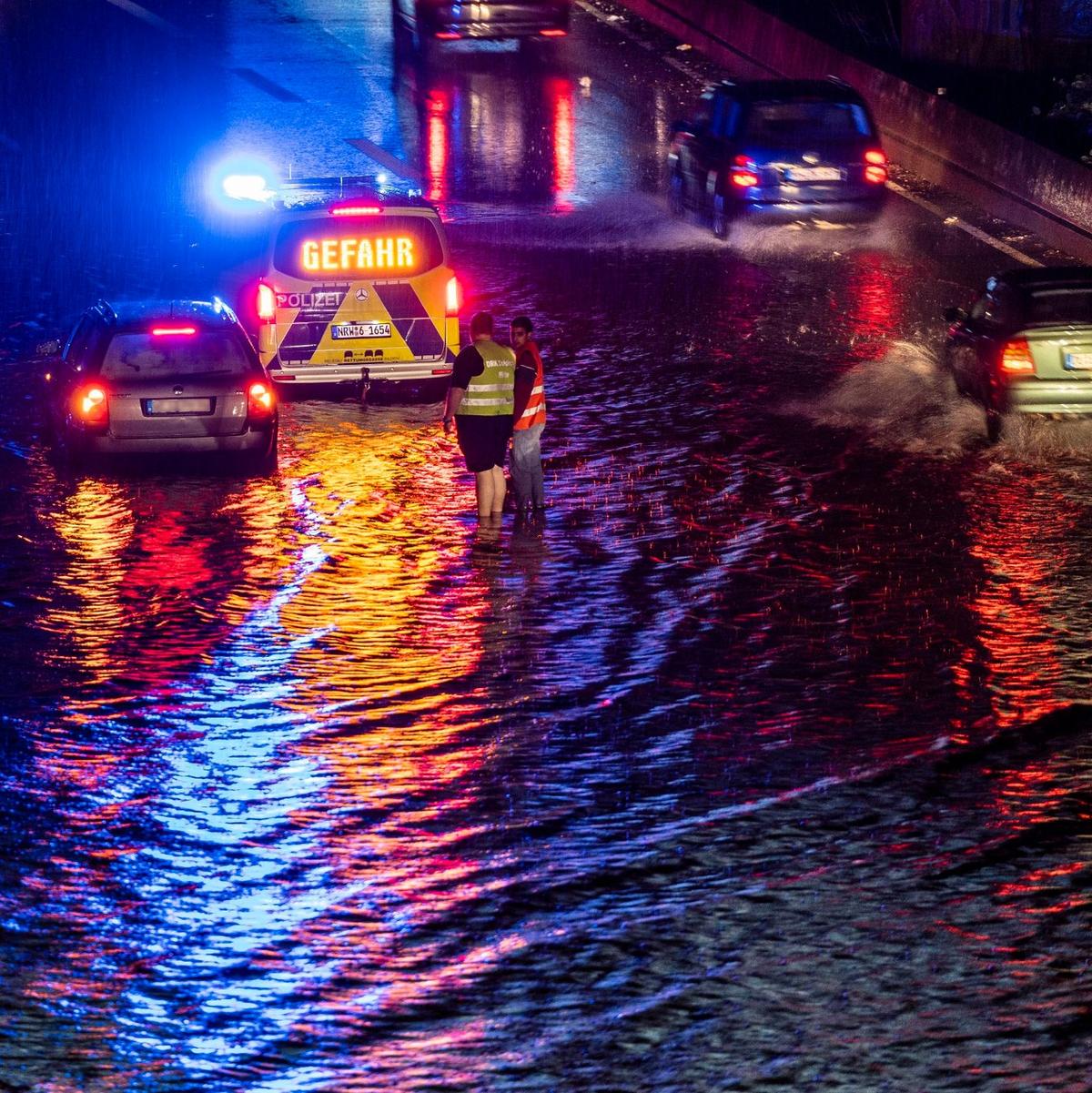 Teilabschnitte der A59 in Duisburg sind nach stundenlangen Regenfällen überschwemmt, Autos fahren durch die Wassermassen. - Foto: Christoph Reichwein/dpa