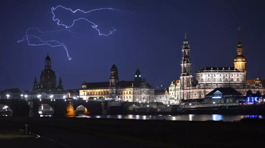 Blitze entladen sich während eines Gewitters am Abend über der Dresdener Altstadt. - Bild: Robert Michael/dpa