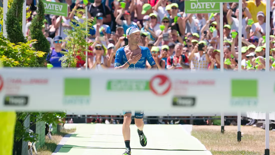 Patrick Lange, Zweitplatzierter der Männer, läuft bei der Triathlon Challenge Roth 2022 ins Ziel ein. - Bild: Nicolas Armer/dpa