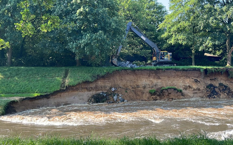 Durch starke Regenfälle ist der Emscherdeich in Dinslaken instabil geworden. Ein Bagger arbeitet, um ihn zu sichern. - Foto: Alex Forstreuter/dpa