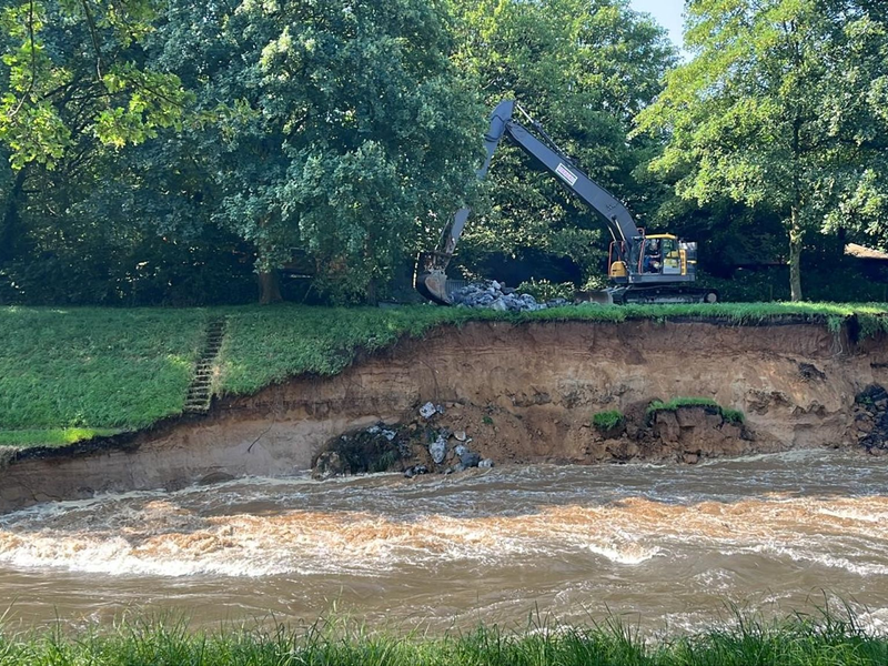 Durch starke Regenfälle ist der Emscherdeich in Dinslaken instabil geworden. Ein Bagger arbeitet, um ihn zu sichern. - Foto: Alex Forstreuter/dpa