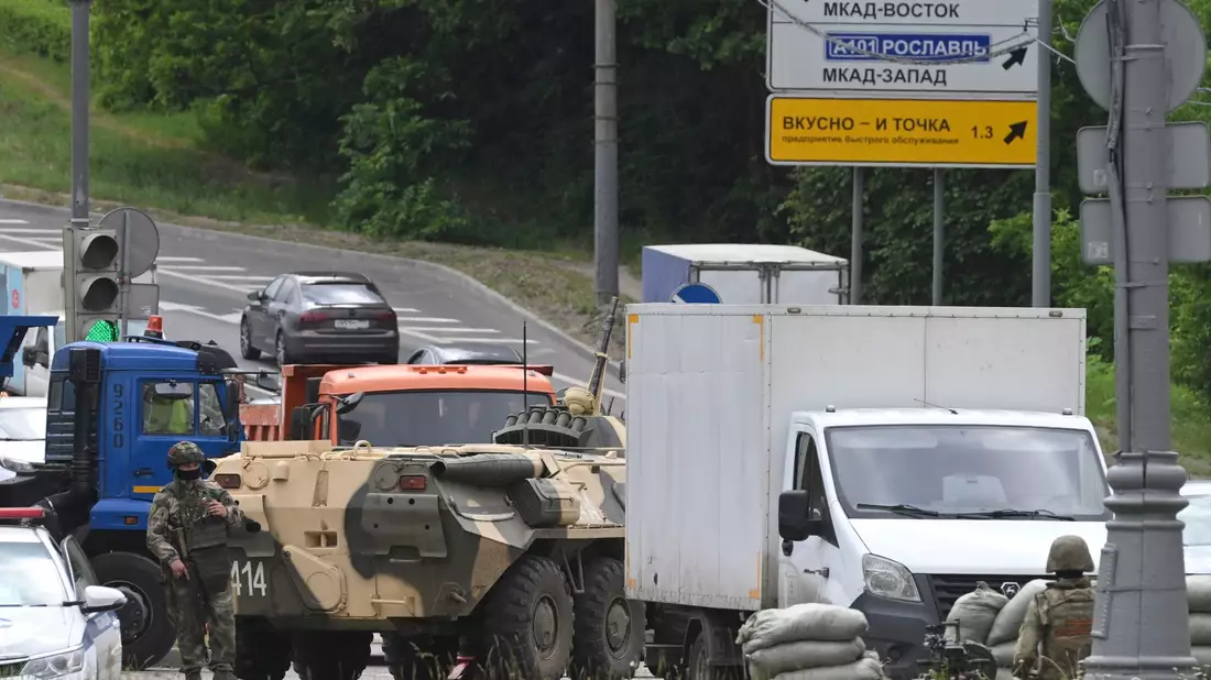 Russische Armeeangehörige bewachen die Autobahn bei Moskau mit einem Mannschaftstransportwagen. - Bild: -/AP/dpa