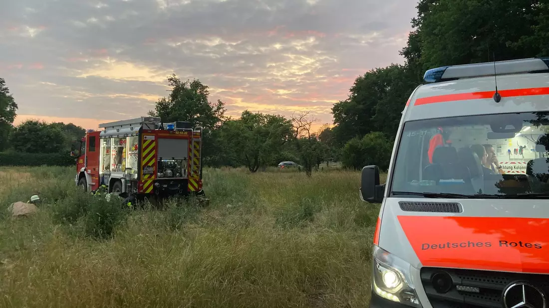 Fahrzeuge von Feuerwehr und Deutsches Rotes Kreuz stehen an einer Wiese. - Bild: Christiane Bosch/dpa