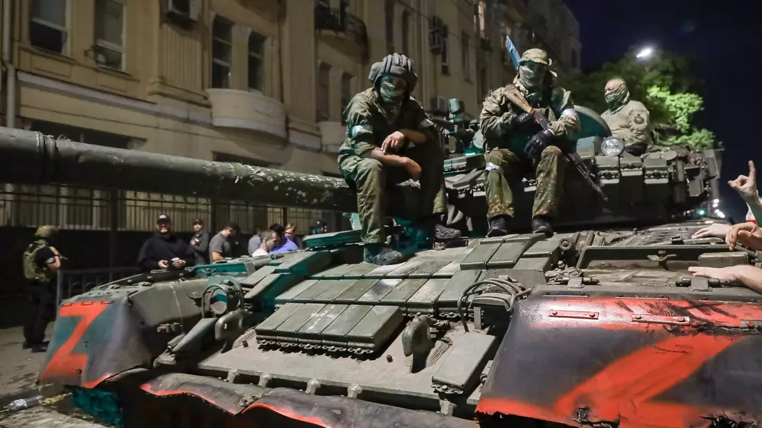Angehörige des Militärunternehmens Wagner Group sitzen auf einem Panzer auf einer Straße in Rostow am Don, Russland, bevor sie einen Bereich im Hauptquartier des südlichen Militärbezirks verlassen. - Bild: -/AP/dpa