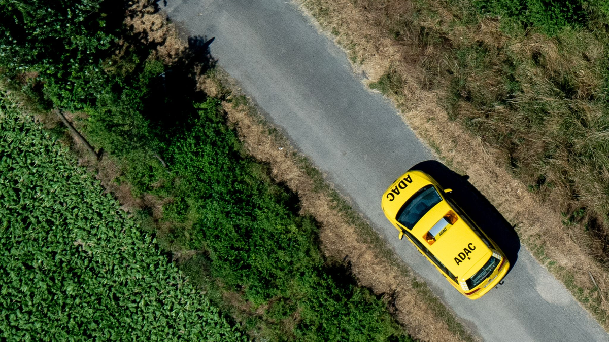 Ein Fahrzeug der ADAC Pannenhilfe fährt über einen Feldweg. - Foto: Hauke-Christian Dittrich/dpa