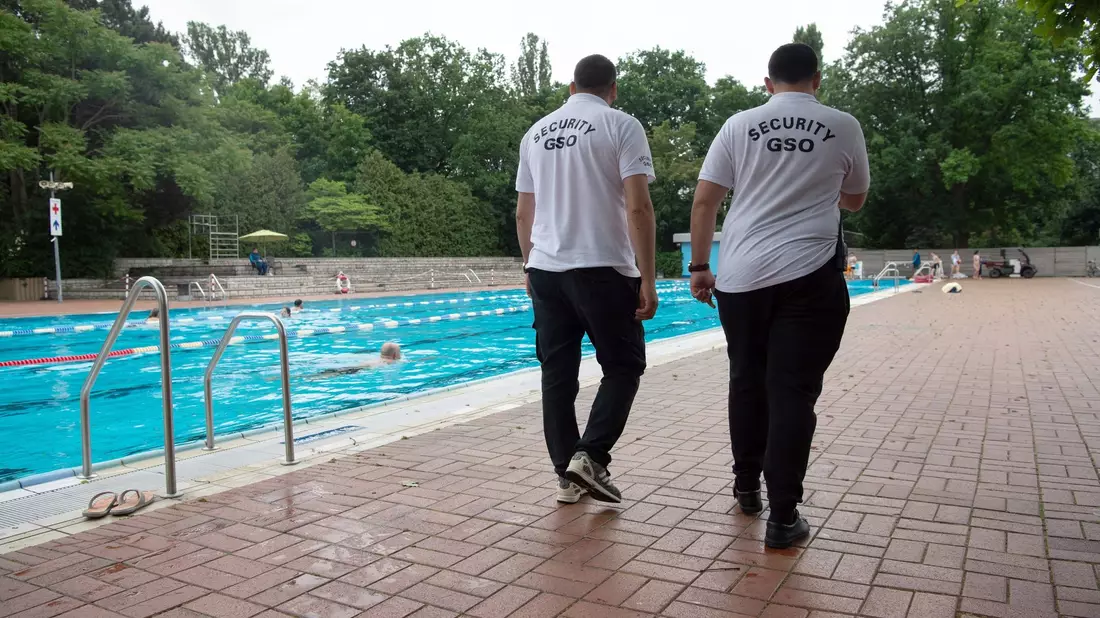Mitarbeiter des Sicherheitsdienstes «Security GSO» drehen im Berliner Prinzenbad ihre Runden. - Bild: Paul Zinken/dpa