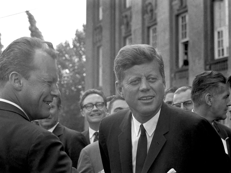 Handschlag in Berlin: US-Präsident John F. Kennedy (M) und der Regierende Bürgermeister von Berlin, Willy Brandt (r), vor dem Schöneberger Rathaus am 26. Juni 1963. Dort sprach Kennedy den legendären Satz «Ich bin ein Berliner». - Foto: picture alliance / dpa