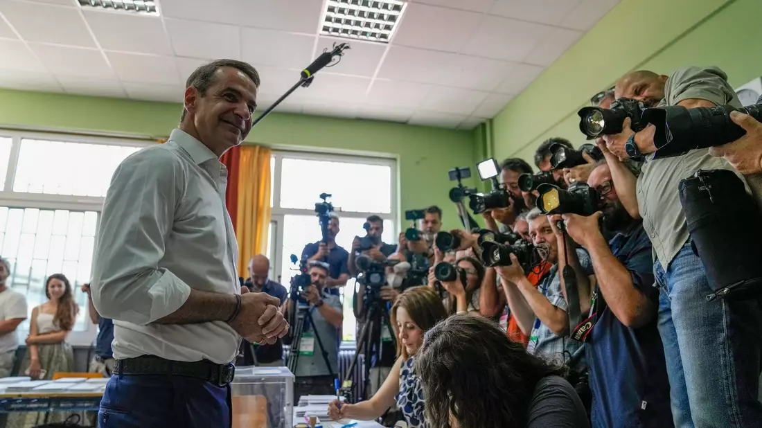 Kyriakos Mitsotakis (l), Vorsitzender der Mitte-Rechts-Partei Neue Demokratie, gibt in einem Wahllokal seine Stimme ab. - Bild: Thanassis Stavrakis/AP/dpa