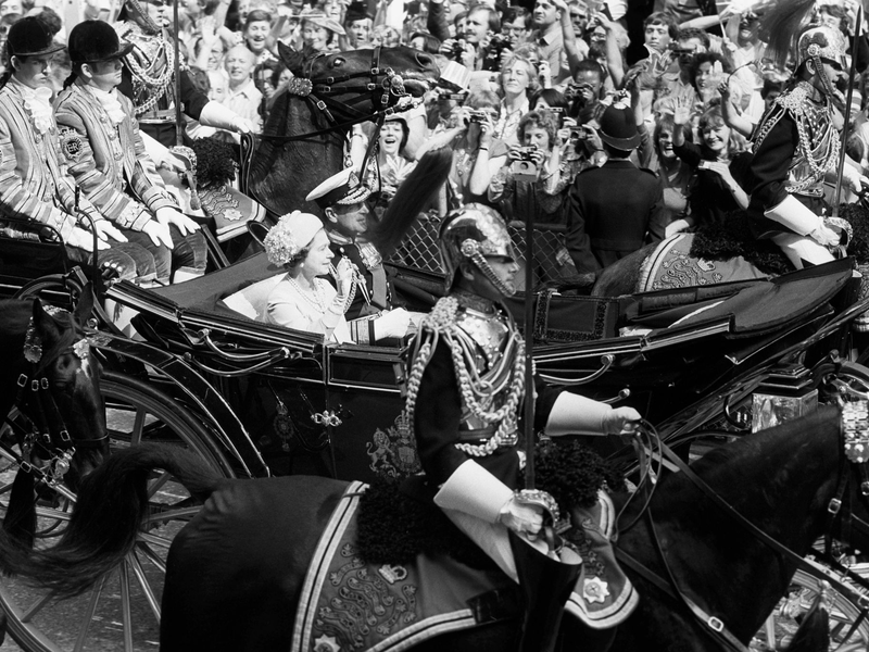 Die Königin und der Herzog von Edinburgh fahren anlässlich der Hochzeit des Prinzen von Wales und Lady Diana Spencer die Fleet Street entlang. Mit dabei: der ehemalige Lakai Paul Whybrew (ganz links). - Foto: Pa/PA Wire/dpa