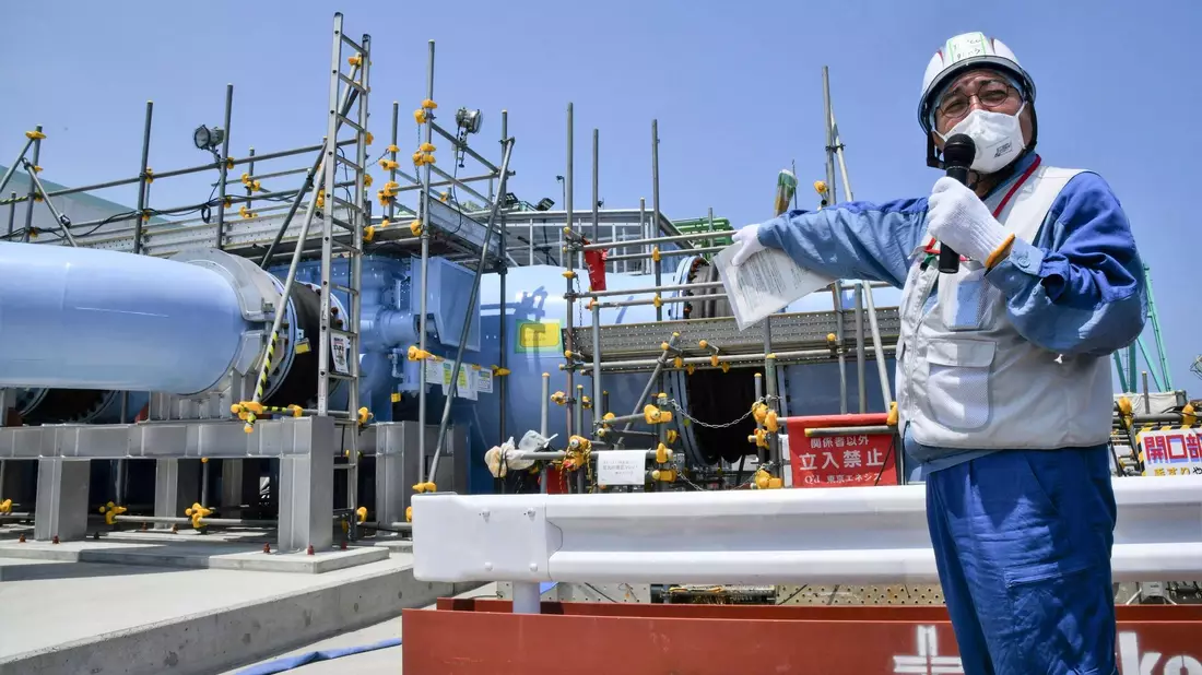 Ein Angestellter erklärt die Anlage, mit der aufbereitetes radioaktives Wasser aus dem Kernkraftwerk Fukushima ins Meer geleitet werden soll. - Bild: Uncredited/Kyodo News/AP/dpa