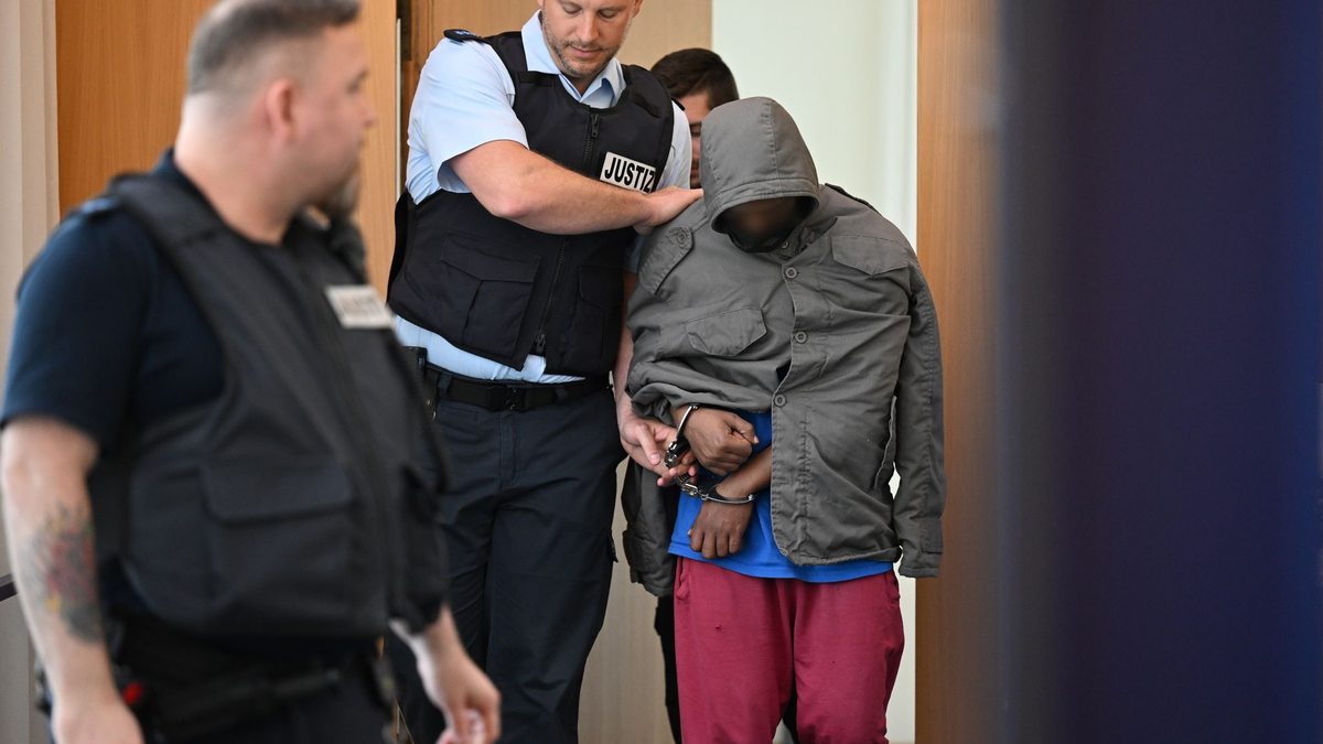 Der Angeklagte wird in Hand- und Fußschellen in den Gerichtssaal geführt. - Foto: Felix Kästle/dpa