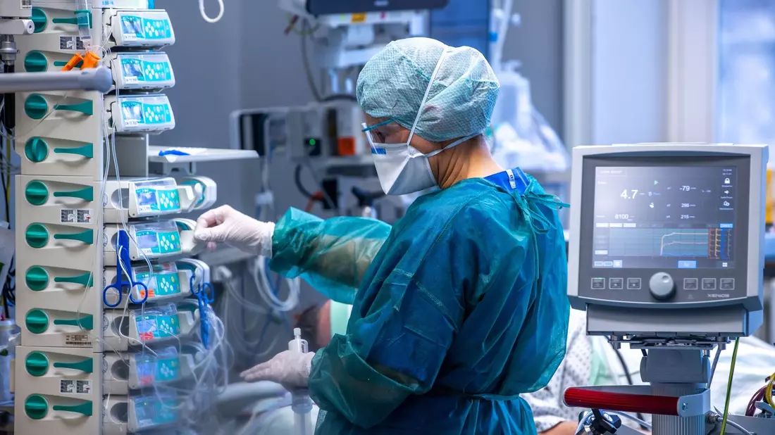 Ärzte und Pflegekräfte betreuen Patienten auf einer Intensivstation. - Bild: Jens Büttner/dpa-Zentralbild/dpa