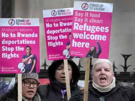 «Stand Up To Racism»-Aktivisten mit Plakaten vor dem High Court in London (Archivbild). - Foto: Kirsty Wigglesworth/AP/dpa