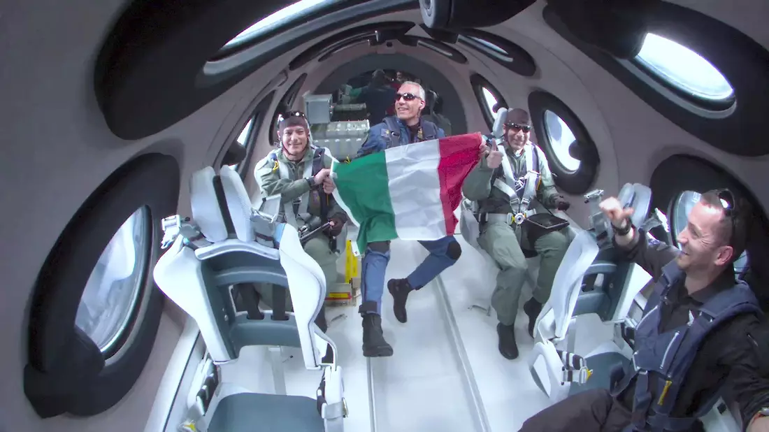 Für einen kurzen Zeitraum durften die drei italienischen Wissenschaftler ihre Sitzplätze verlassen, erlebten Schwerelosigkeit und rollten eine italienische Flagge aus. - Bild: Uncredited/Virgin Galactic/AP/dpa