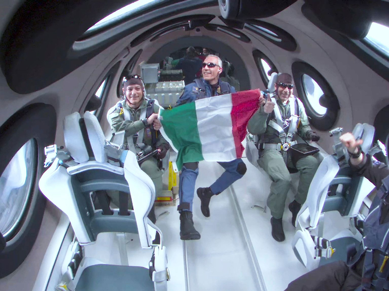 Für einen kurzen Zeitraum durften die drei italienischen Wissenschaftler ihre Sitzplätze verlassen, erlebten Schwerelosigkeit und rollten eine italienische Flagge aus. - Foto: Uncredited/Virgin Galactic/AP/dpa