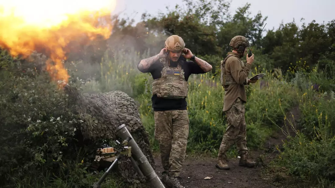 Ein ukrainischer Soldat während eines Funkgesprächs, während ein anderer Soldat 82-mm-Mörser auf russische Stellungen an der Frontlinie in der Nähe Bachmut feuert. - Bild: Alex Babenko/AP/dpa