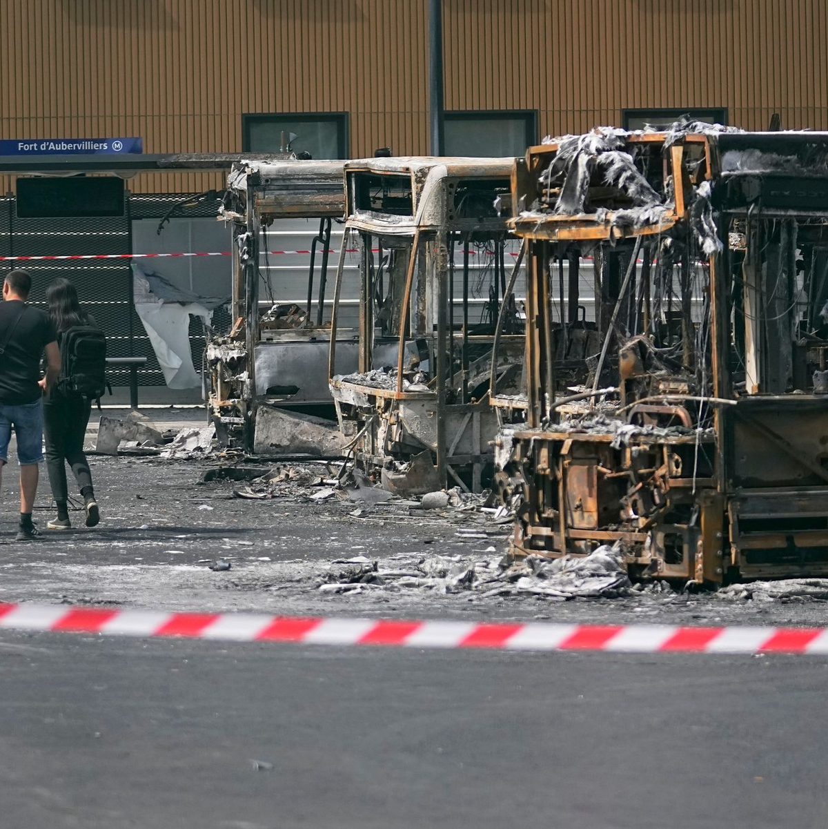 Polizeiermittler vor ausgebrannten Bussen in Aubervilliers. - Foto: Michel Euler/AP/dpa