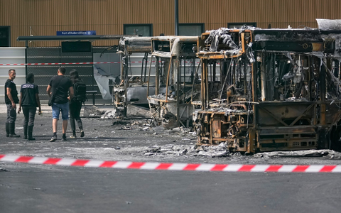 Polizeiermittler vor ausgebrannten Bussen in Aubervilliers. - Foto: Michel Euler/AP/dpa