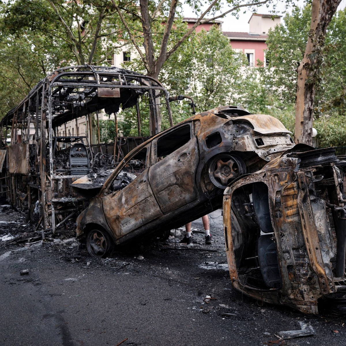 Ausgebrannte Autos und ein Bus stehen in einer Straße in Lyon. - Foto: Laurent Cipriani/AP
