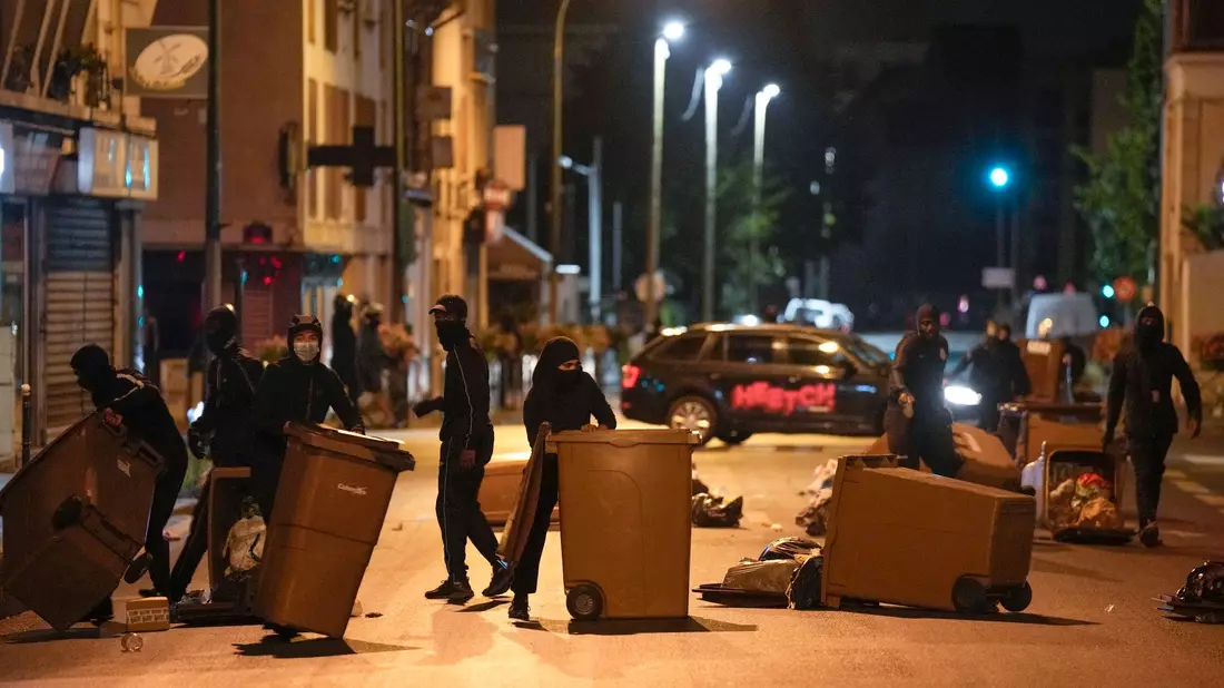 Protestierende blockieren eine Straße mit Mülleimern in Colombes, außerhalb von Paris. - Bild: Lewis Joly/AP