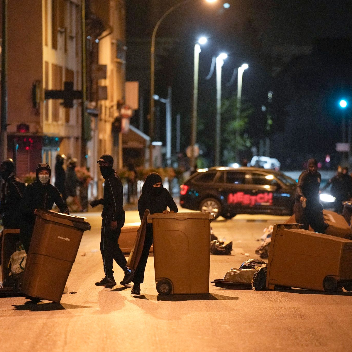 Protestierende blockieren eine Straße in Colombes außerhalb von Paris mit Mülleimern. - Foto: Lewis Joly/AP