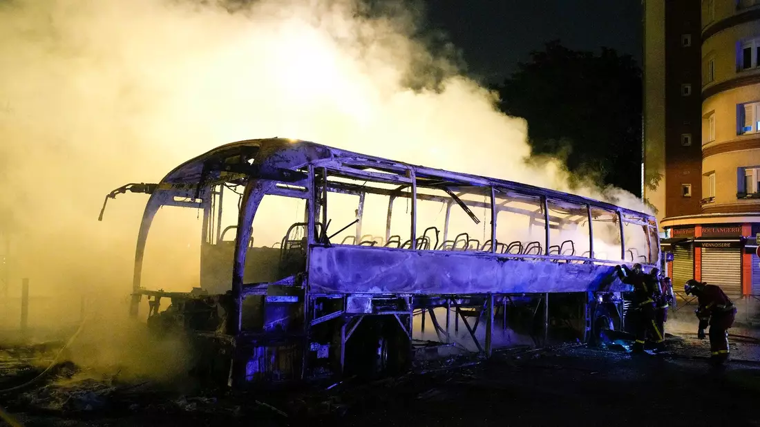 Rauch steigt bei nächtlichen Krawallen aus einem ausgebrannten Bus in Nanterre. - Bild: Lewis Joly/AP/dpa