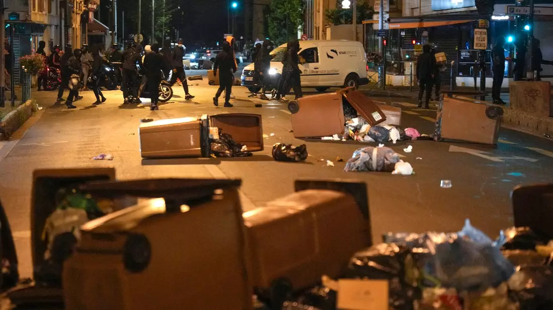 Protestierende blockieren eine Straße mit Mülleimern in Colombes, außerhalb von Paris. - Bild: Lewis Joly/AP