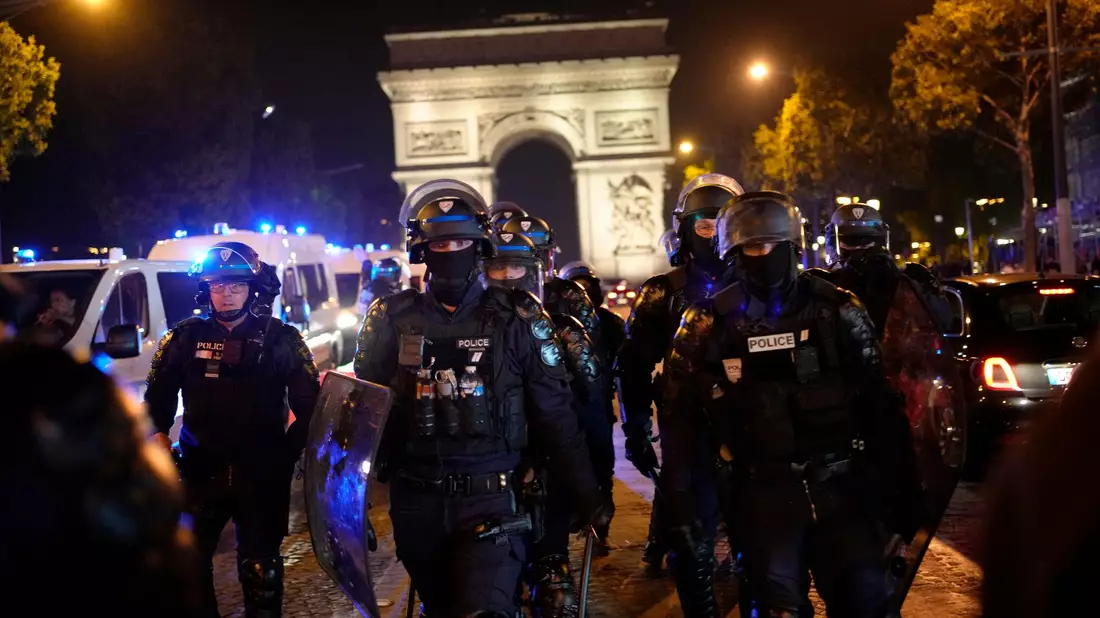 Polizisten patrouillieren vor dem Arc de Triomphe auf der Champs Élysées. - Bild: Christophe Ena/AP