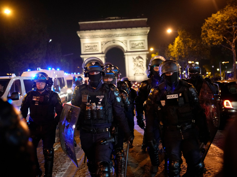 Polizisten patrouillieren vor dem Arc de Triomphe auf der Champs Élysées. - Foto: Christophe Ena/AP