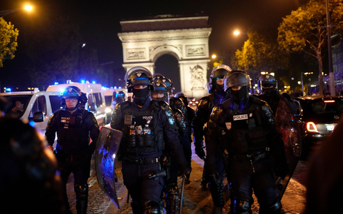 Polizisten patrouillieren vor dem Arc de Triomphe auf den Champs Élysées. - Foto: Christophe Ena/AP