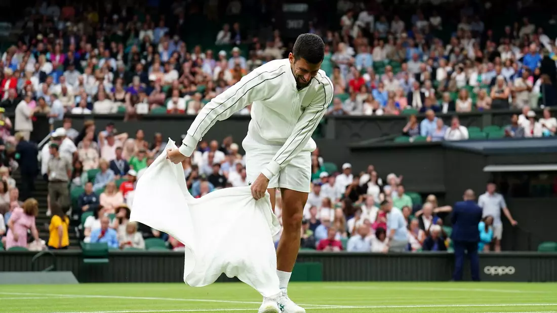 Novak Djokovic trocknet während der Regenunterbrechung den Rasen. - Bild: Zac Goodwin/PA Wire/dpa