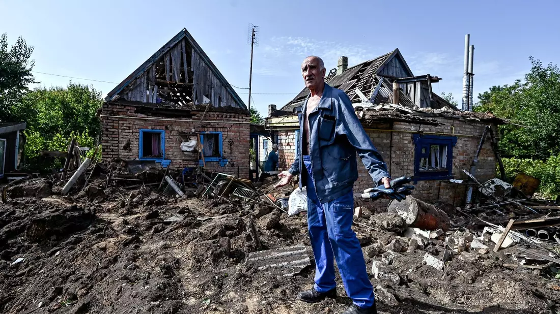 Ein Hausbesitzer begutachtet seinen Hof im Dorf Kuschuhum, in den eine mutmaßlich russische Granate eingeschlagen ist. - Bild: ---/Ukrinform/dpa