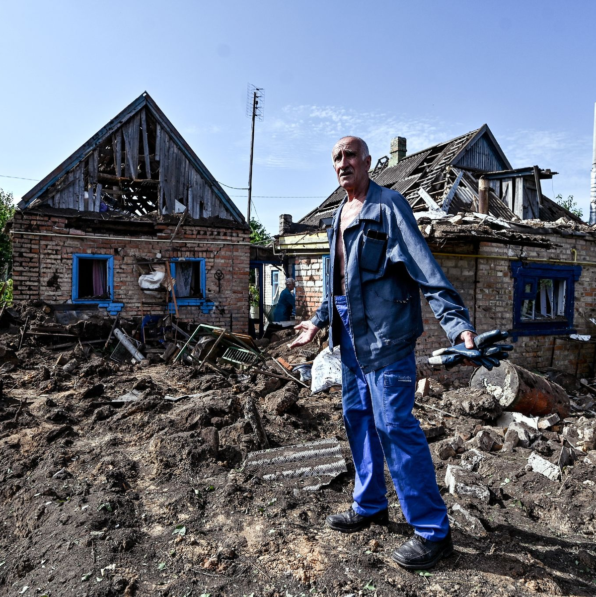 Ein Hausbesitzer begutachtet seinen Hof im Dorf Kuschuhum, in den eine mutmaßlich russische Granate eingeschlagen ist. - Foto: ---/Ukrinform/dpa