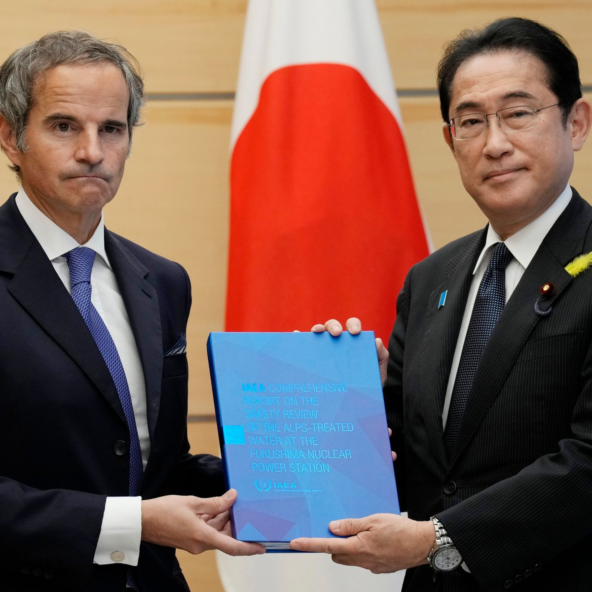 IAEA-Generaldirektor Rafael Grossi (l) überreicht Japans Ministerpräsident Fumio Kishida den Abschlussbericht der Internationalen Atomenergiebehörde. - Foto: Eugene Hoshiko/Pool AP/AP/dpa