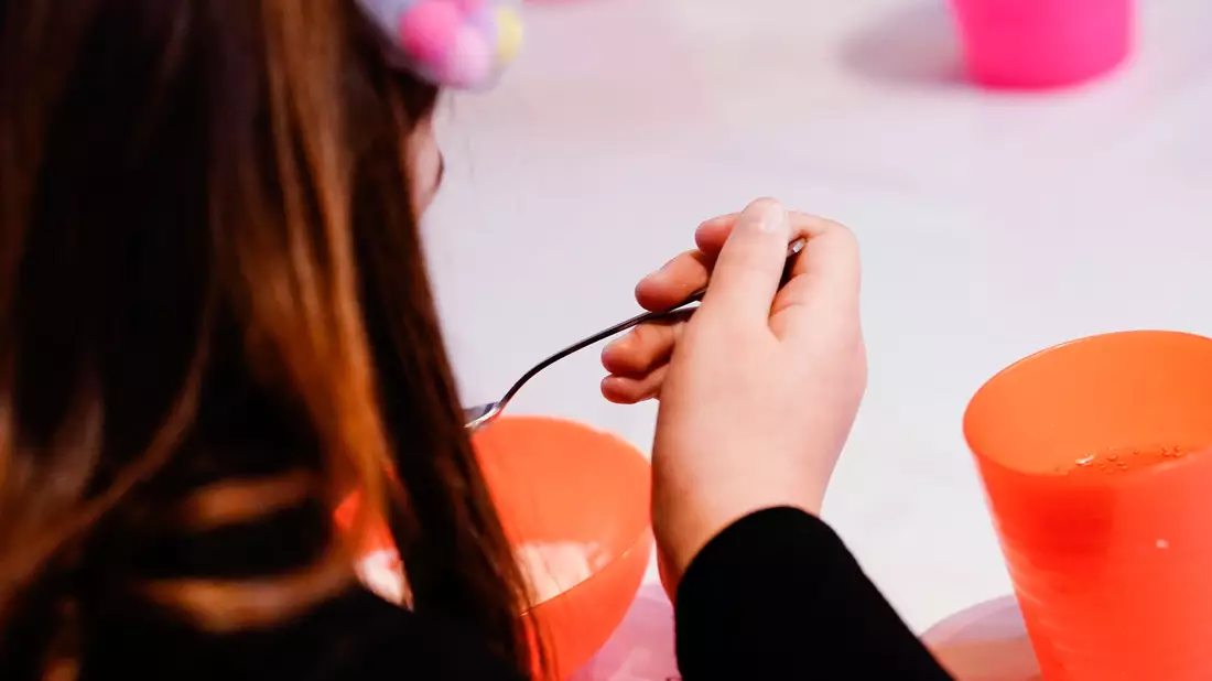 Ein Kind isst bei der Mannheimer Kindervesperkirche (Symbolbild). Laut Familienministerin Paus soll mit der Einführung der Kindergrundsicherung Kinderarmut in Deutschland effektiv bekämpft werden. - Bild: Uwe Anspach/dpa