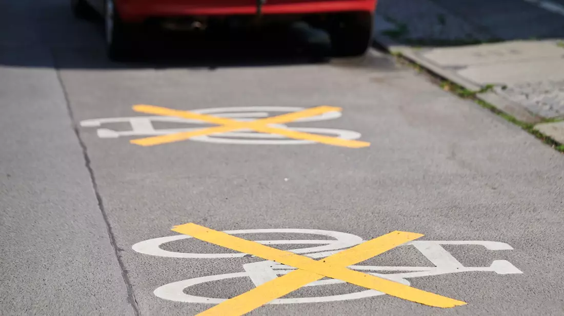 Auf der Ollenhauer Straße sind die Zeichen für den Radweg mit gelben Kreuzen zugeklebt und Autos parken darauf. Der Radweg existiert nicht mehr. - Bild: Annette Riedl/dpa