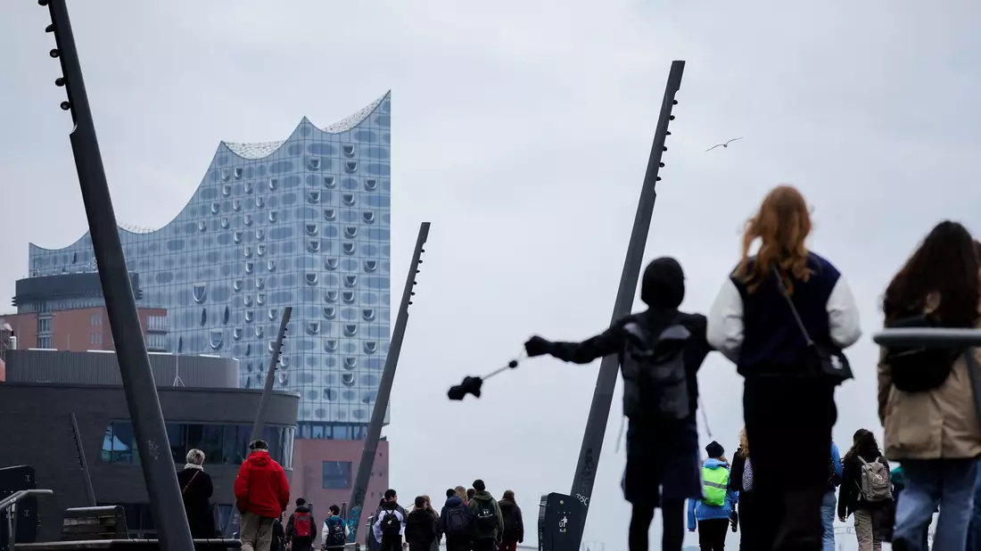 Stürmischer Wind im Hamburger Hafen vor der Silhouette der Elbphilharmonie. - Bild: Christian Charisius/dpa