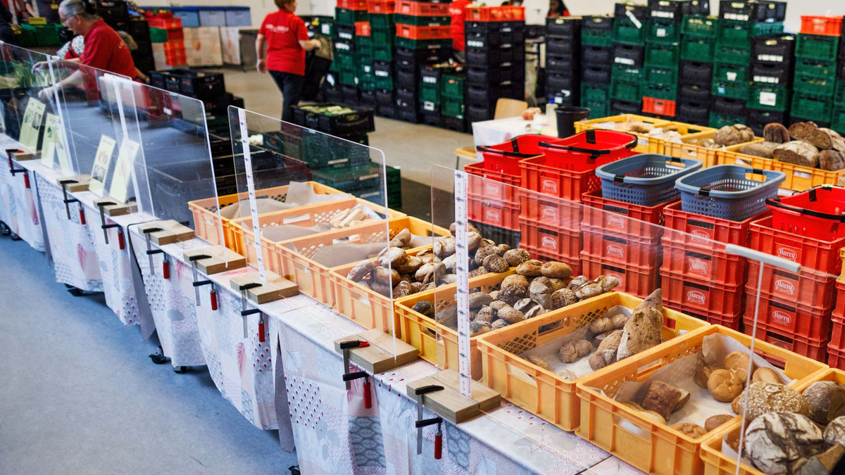 Mitarbeiter stehen in einer Ausgabestelle der Berliner Tafel. - Foto: Carsten Koall/dpa