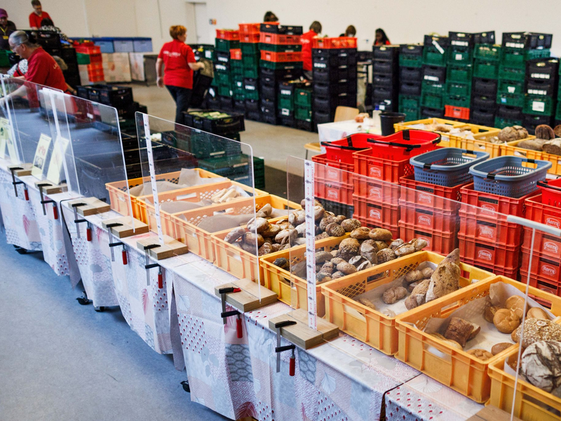 Mitarbeiter stehen in einer Ausgabestelle der Berliner Tafel. - Foto: Carsten Koall/dpa