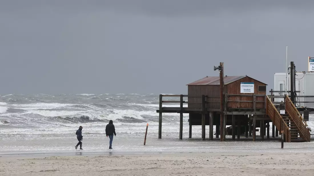 Windböen des Sturmtiefs «Poly» fegen über den Strand von St. Peter Ording. - Bild: Bodo Marks/Bodo Marks/dpa
