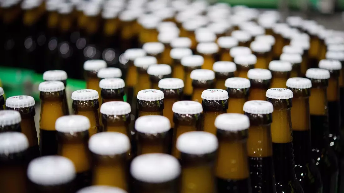 Bierflaschen mit Kronkorken in der Produktion einer Brauerei: «Der Promotionpreis von 9,99 Euro je Kiste verschwindet allmählich.» - Bild: Rainer Jensen/dpa