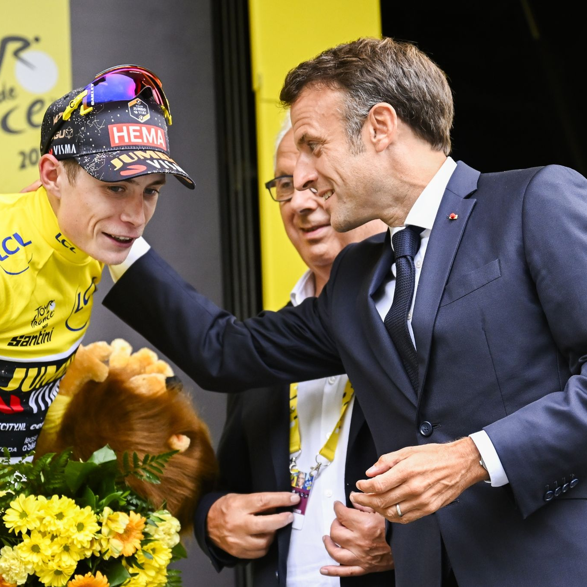 Frankreichs Präsident Emmanuel Macron (r) gratuliert dem neuen Gesamtführenden Jonas Vingegaard. - Foto: Dirk Waem/Belga/dpa