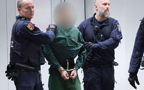 Der Angeklagte Ibrahim A. wird von Justizbeamten an seinen Platz im Gerichtssaal gebracht. - Foto: Christian Charisius/dpa