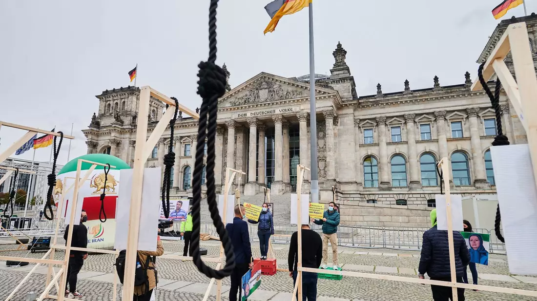 Demonstranten stehen mit symbolischen Galgen vor dem Reichstag und demonstrieren gegen Hinrichtungen und die Todesstrafe im Iran. - Bild: Annette Riedl/dpa/Symbolbild