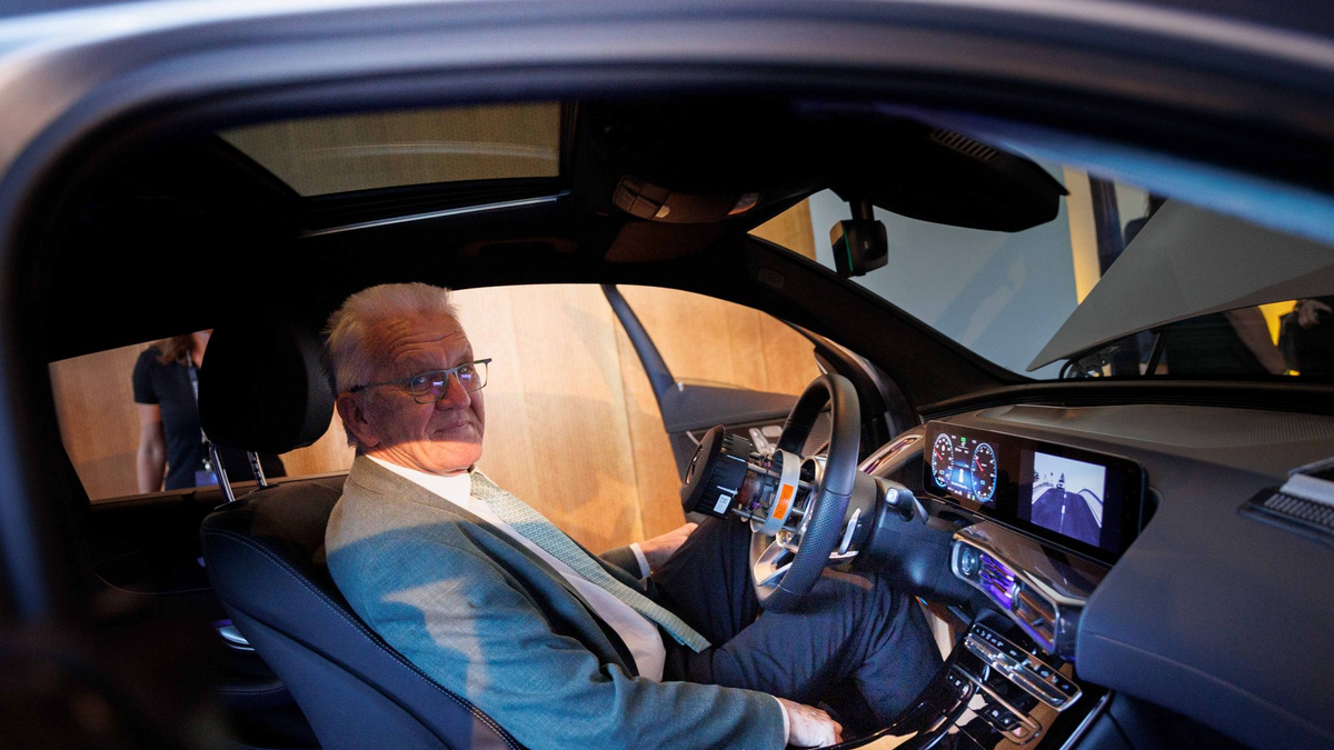 Winfried Kretschmann sitzt in einem Mercedes EQC. - Foto: Carsten Koall/dpa