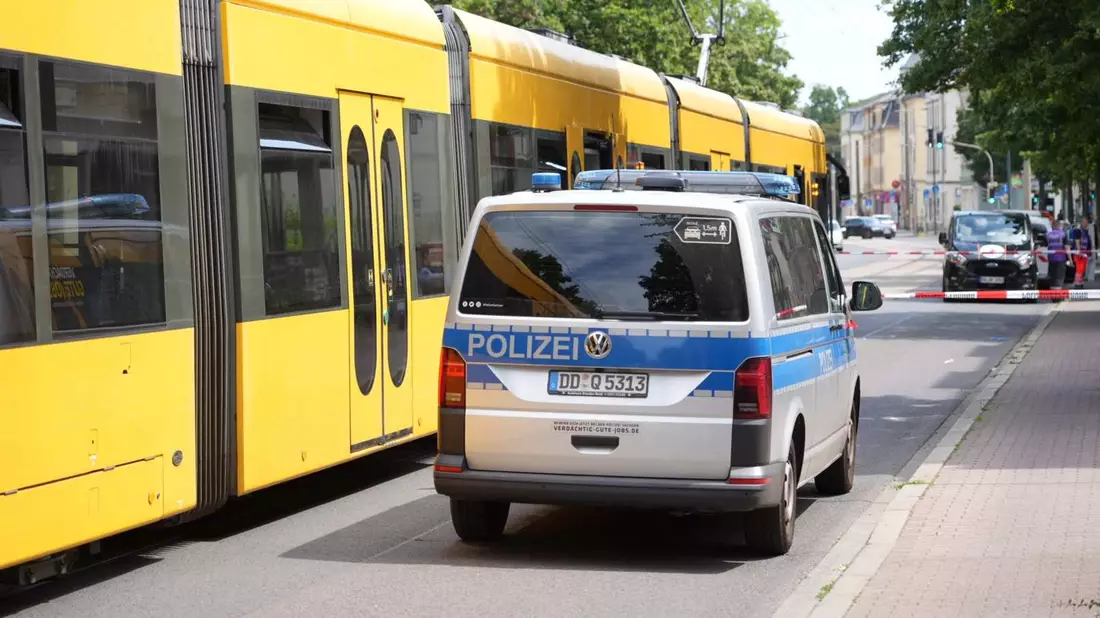 Ein Polizeiauto steht vor der Straßenbahn in Desden, in der ein Mann mit einem Messer attaktiert wurde. - Bild: Benedict Bartsch/xcitepress/dpa