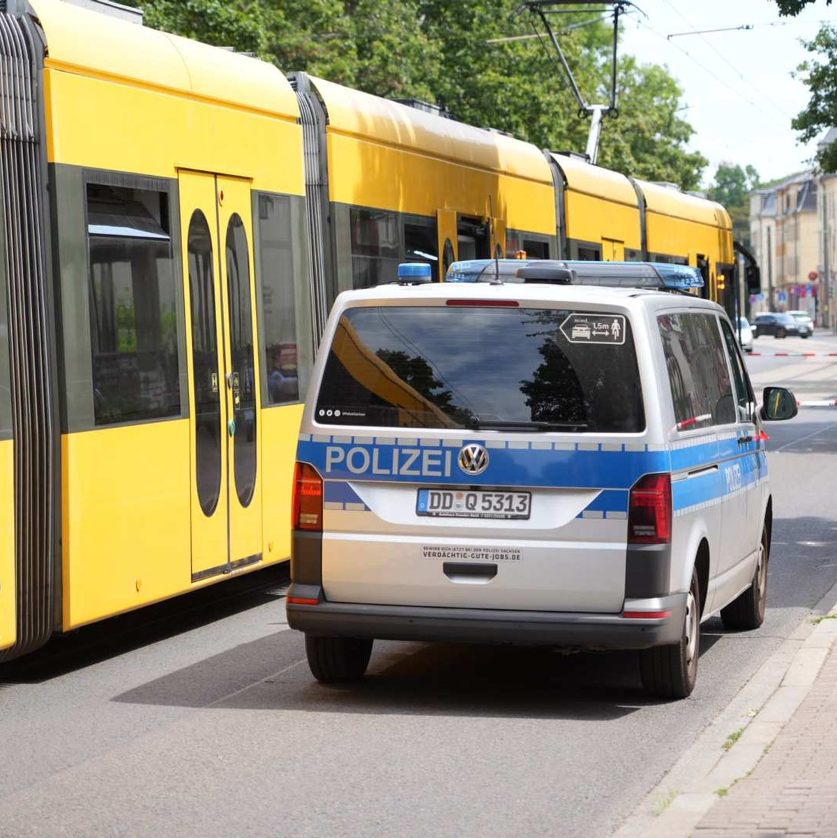 Ein Polizeiauto steht vor der Straßenbahn in Desden, in der ein Mann mit einem Messer attaktiert wurde. - Foto: Benedict Bartsch/xcitepress/dpa
