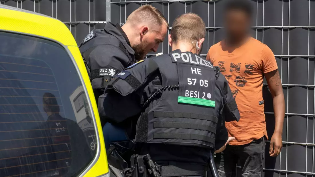 Polizisten kontrollieren am Rande des Eritrea-Festivals in Gießen eine Person. - Bild: Helmut Fricke/dpa