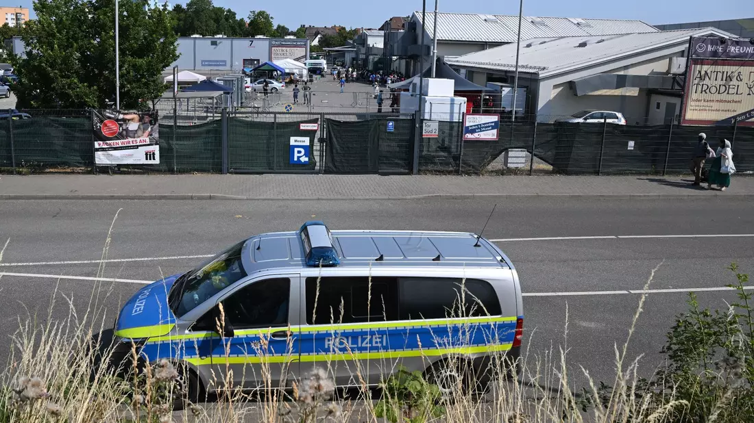 Polizeifahrzeug vor dem Messegelände. - Bild: Arne Dedert/dpa
